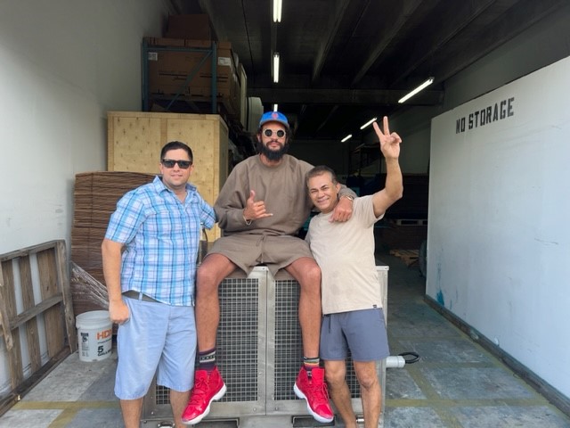 Altitude Water team members Alvaro, Jaymie, and Joakim with the T-200 atmospheric water generator, preparing the unit for clean drinking water relief efforts in Cameroon.