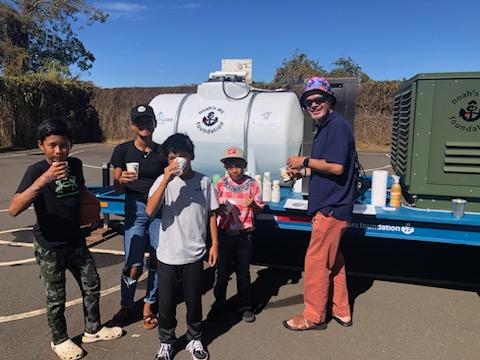 Altitude Water atmospheric water generator providing clean drinking water to families at a community event, showcasing sustainable water access and local impact.