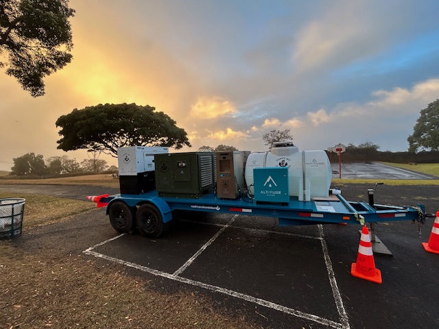 Altitude Water mobile atmospheric water generator trailer with storage tanks producing clean drinking water from air at a community event.