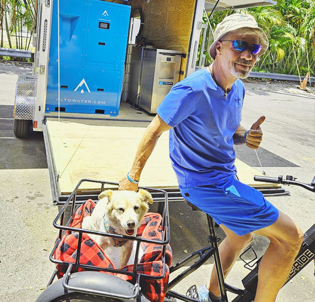 Jeff Szur beside Altitude Water atmospheric water generator unit supporting sustainable drinking water solutions